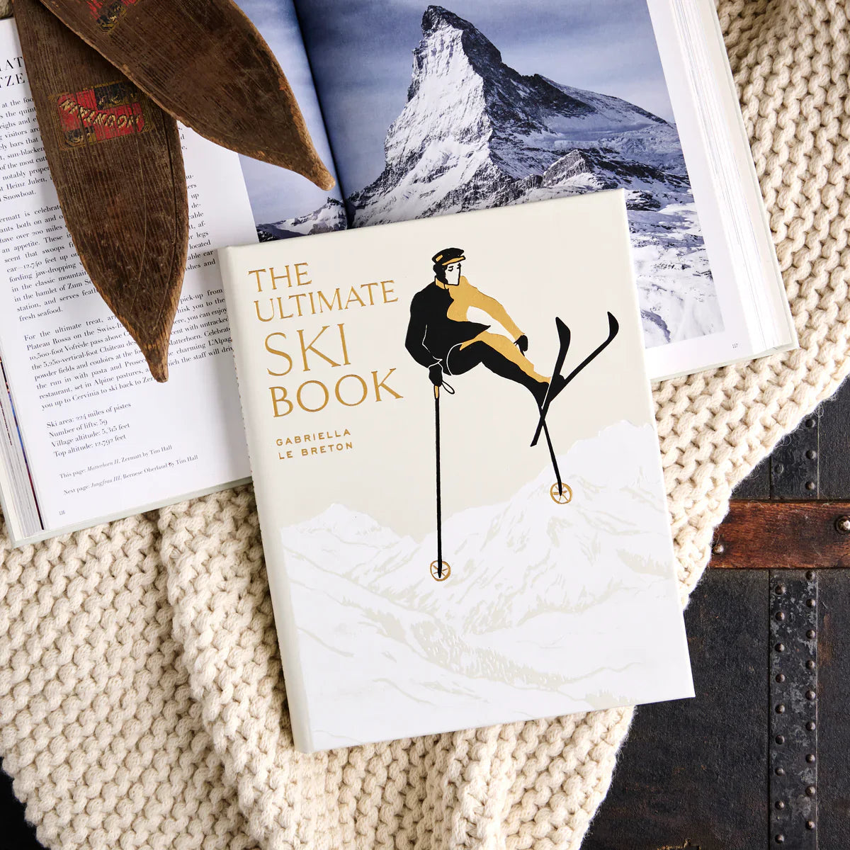 The Ultimate Ski Book laying on a knit blanket