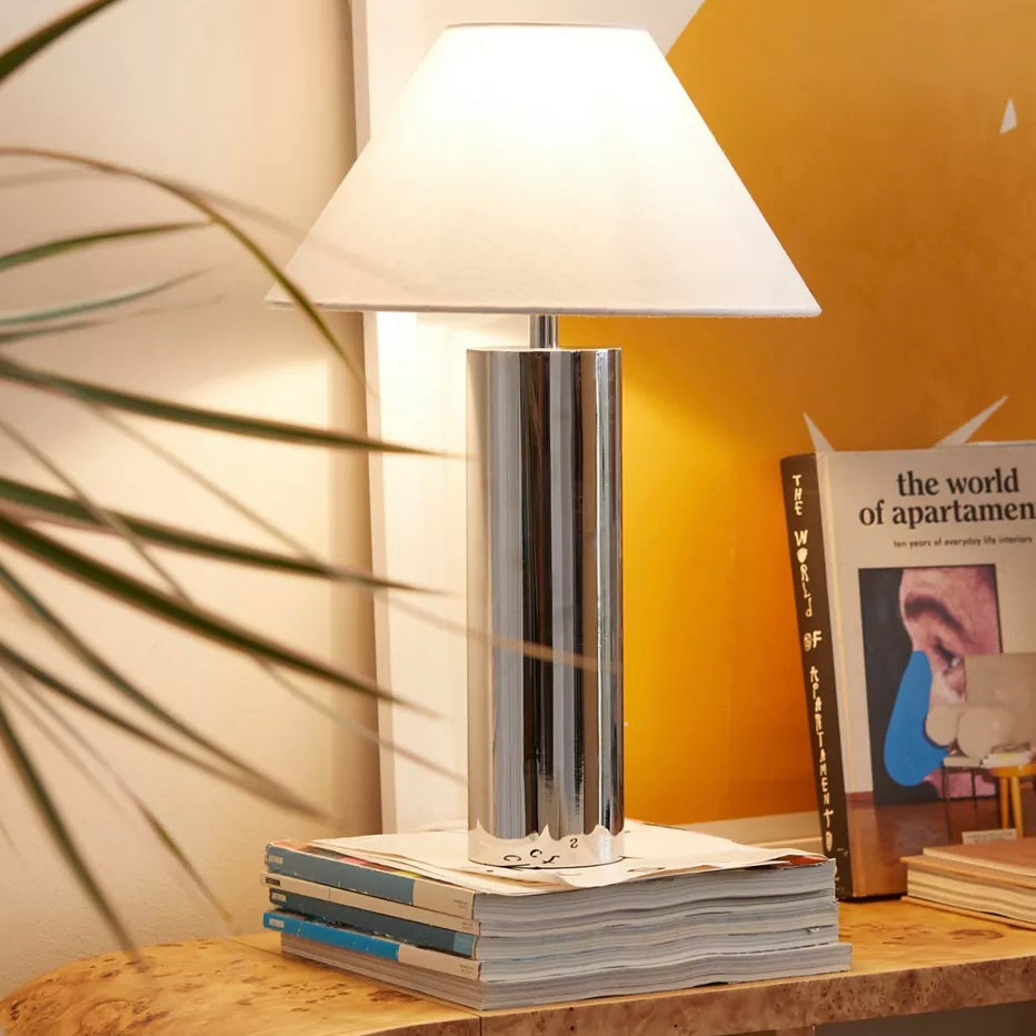Contemporary silver lamp on stack of magazines