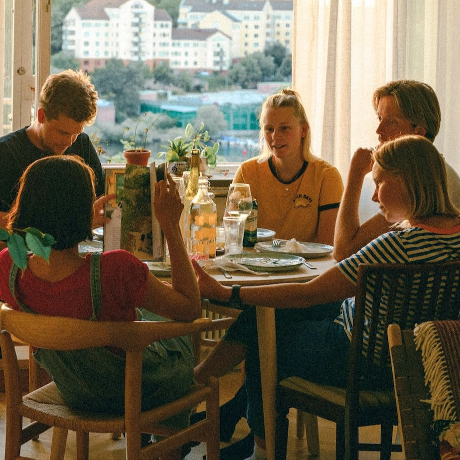 Friends sitting and hangin out around a c round dining room table