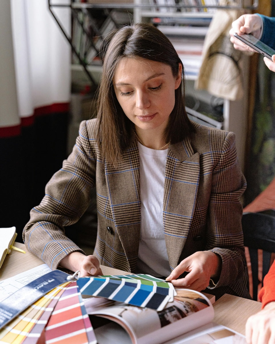 Woman interior designer looking at color swatches in an office setting