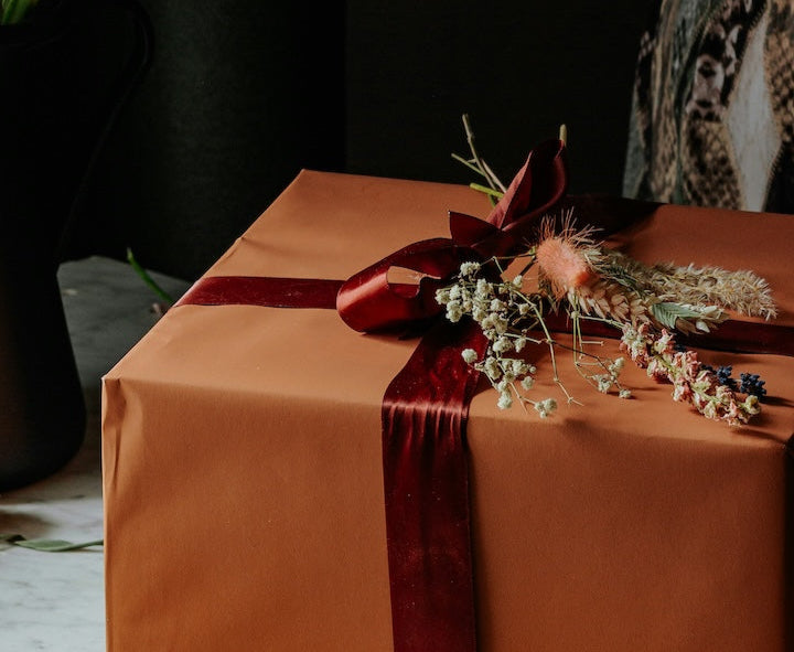 Gift with orange wrapping paper and red ribbon