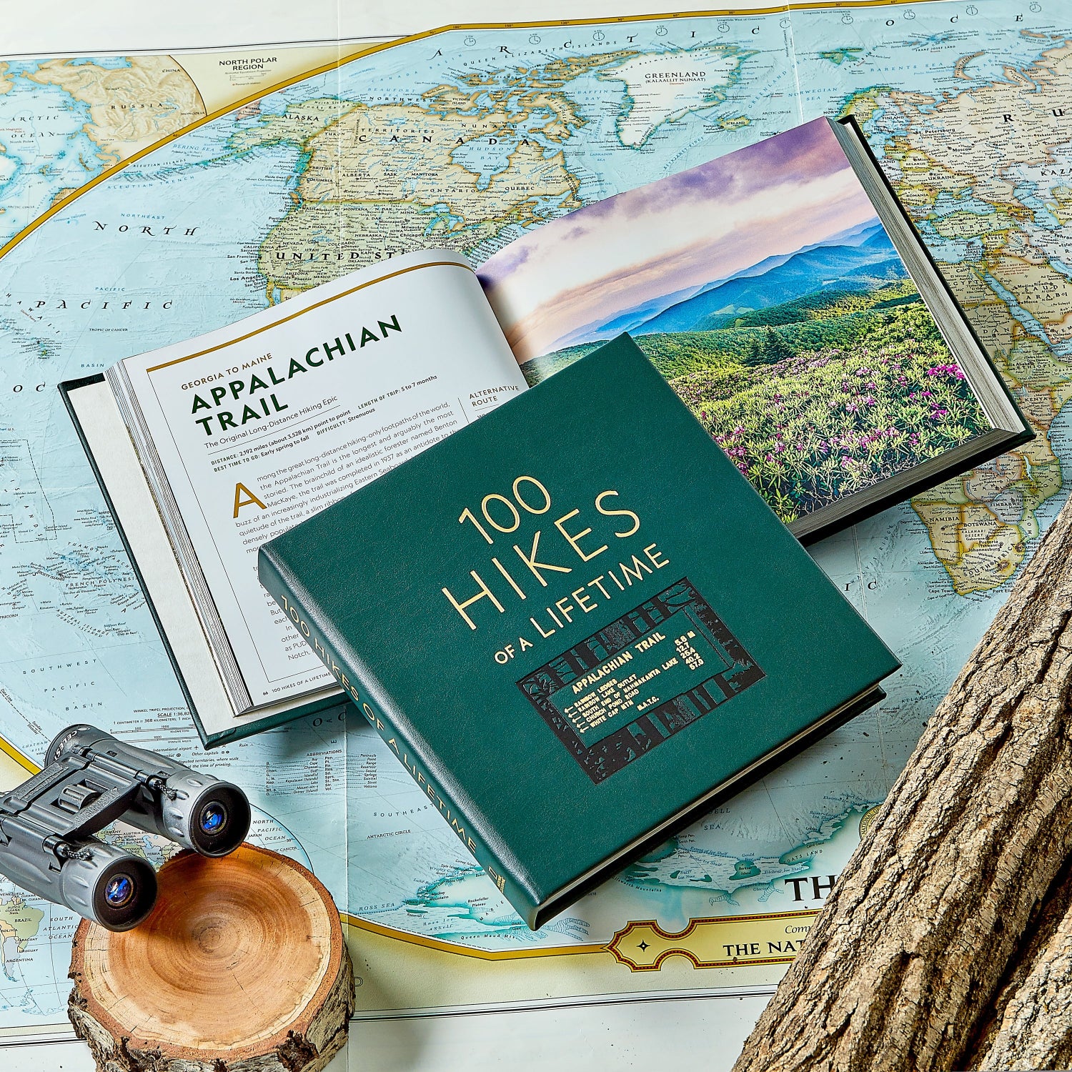 100 Hikes Of A Lifetime book on top of a map
