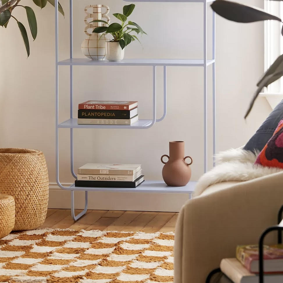 Blue bookshelf with coffe table books and vases