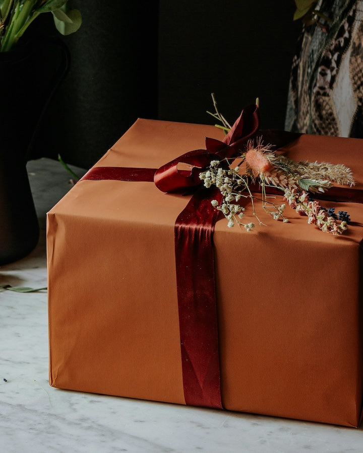 Gift with orange wrapping paper and red ribbon