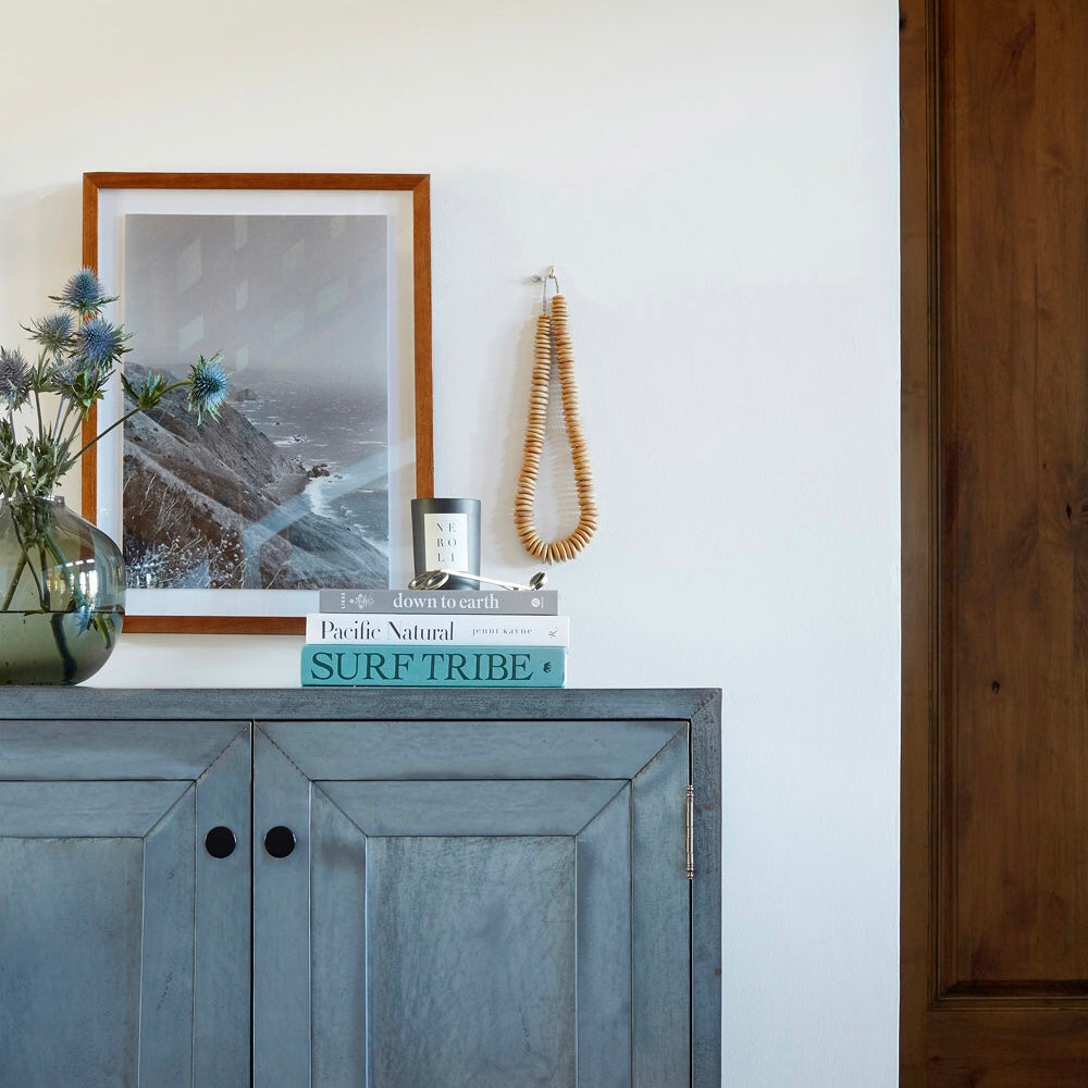 Blue sideboard with stack of coffee table books