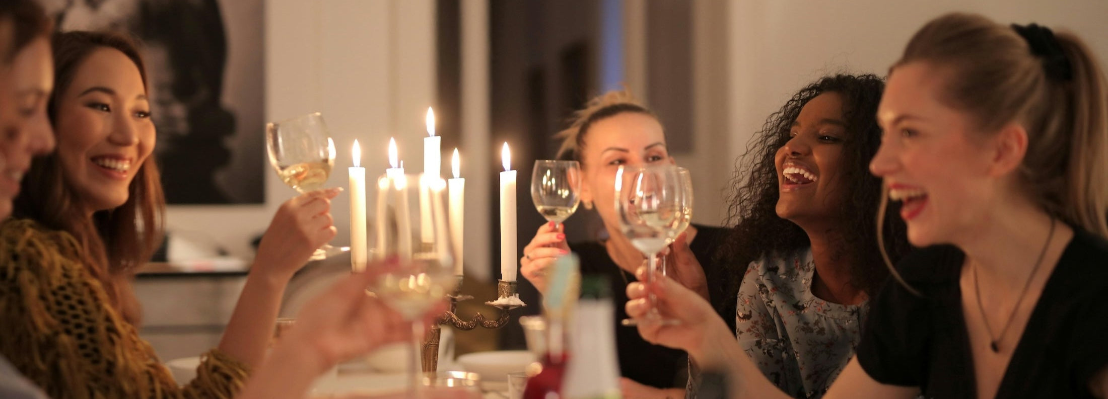 Group of women at dinner party holding wine glasses