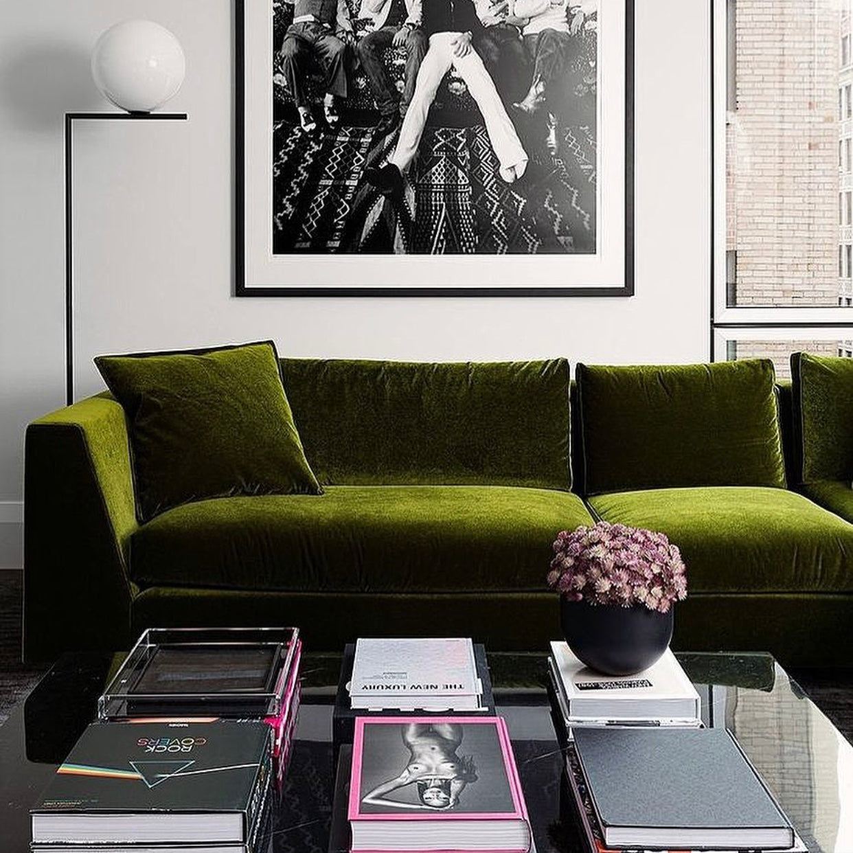Green couch with pink black coffee table books